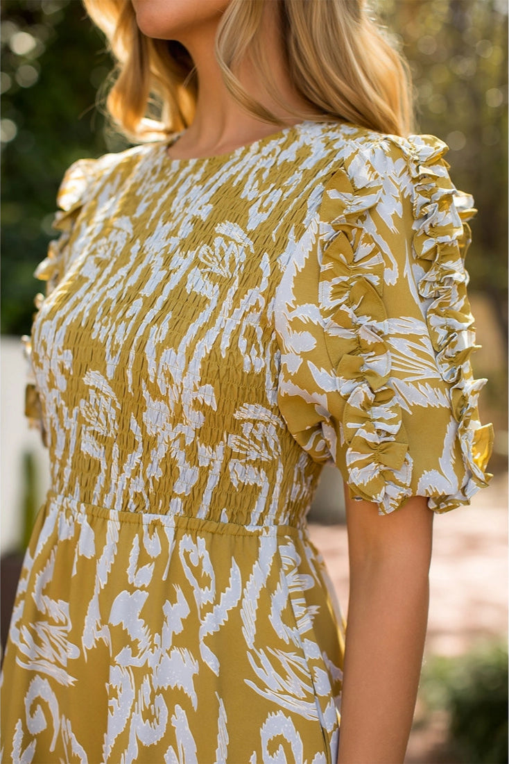 Yellow dress with white floral pattern worn by a person outdoors