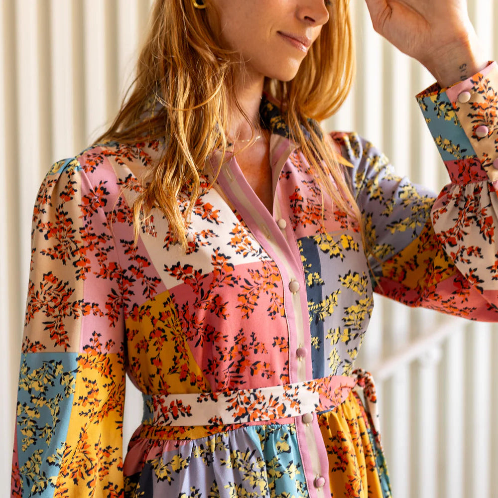 Woman wearing a colorful floral dress with a neutral background